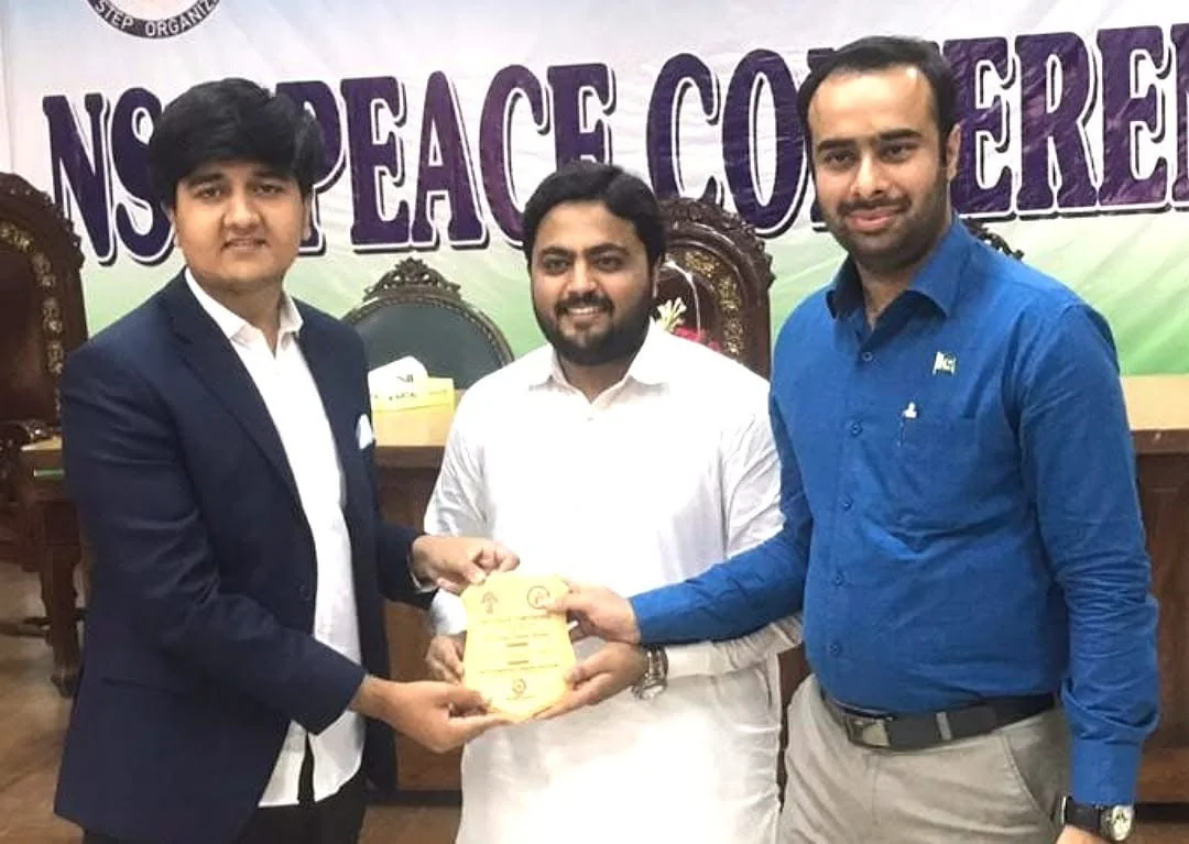 Salman Ahmad Awan receiving recognition in a conference setting