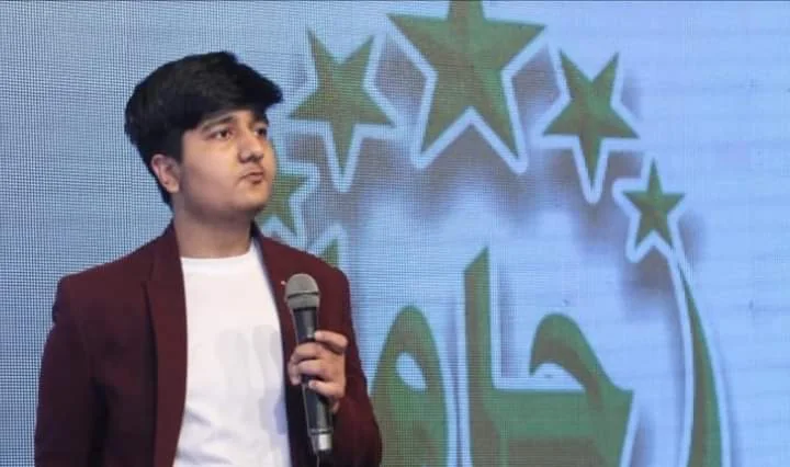 Salman Ahmad Awan speaking on stage holding a microphone