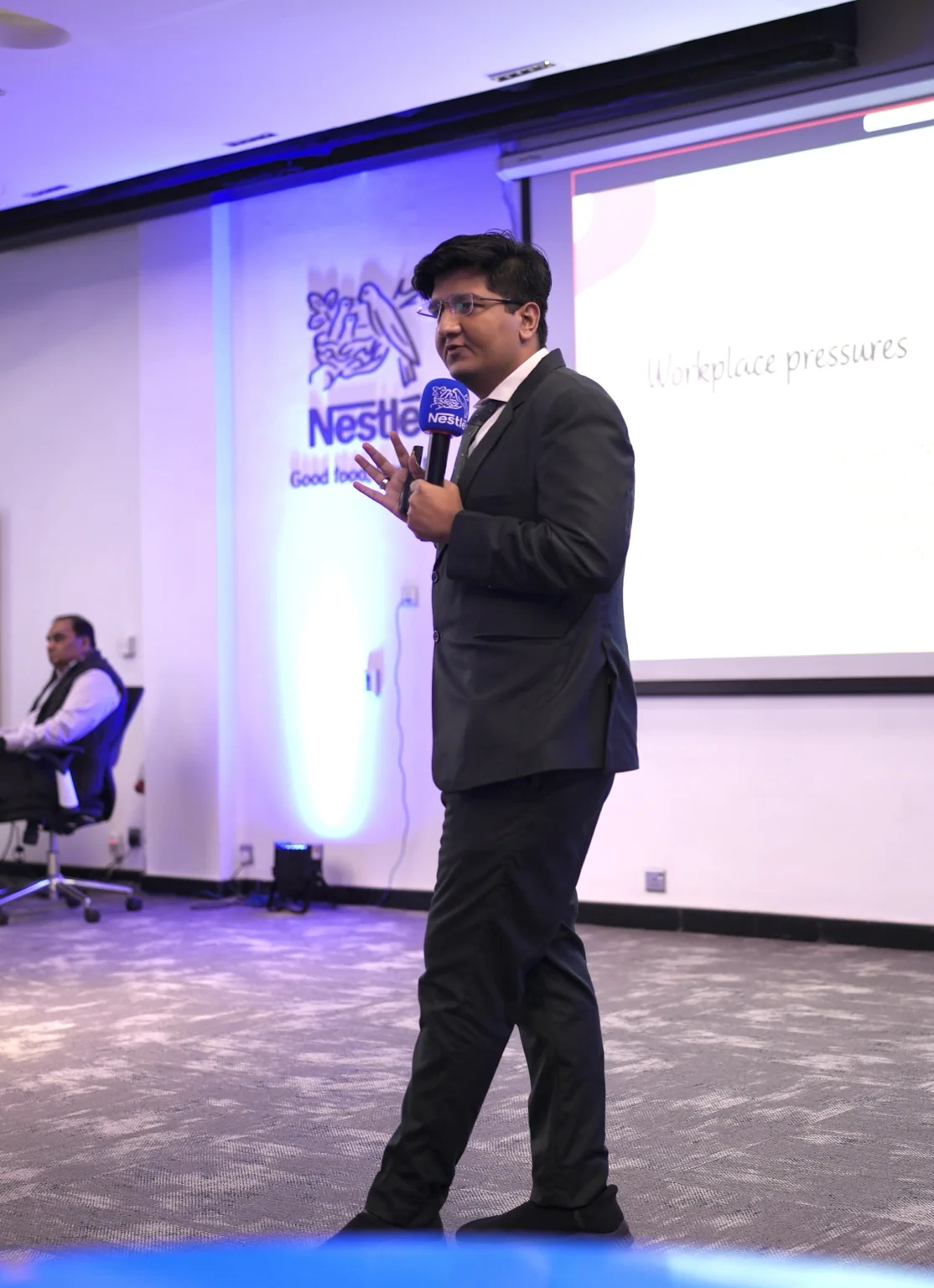 Salman Ahmad Awan speaking on stage at an event